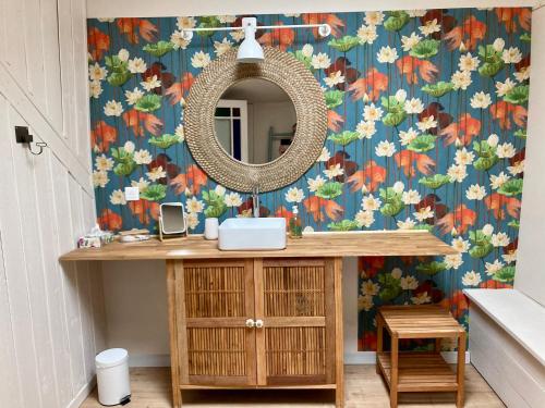 W łazience znajduje się umywalka i lustro. w obiekcie 16 Bis-Gîte-Hôtel-Studio w mieście Marssac-sur-Tarn