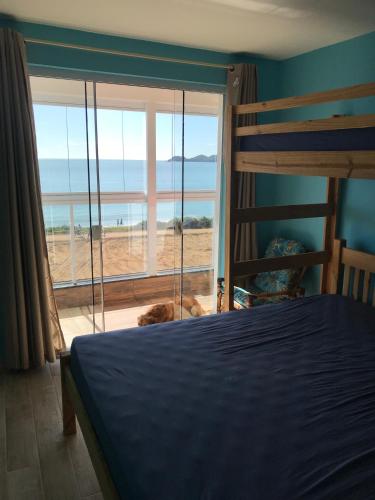 1 dormitorio con cama y vistas al océano en Melhor vista para o mar, en Penha