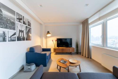 sala de estar con sofá azul y TV en Wonderful Two Bedroom Apartment at Limpertsberg with Parking, near Tram, en Luxemburgo