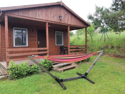 a hammock in front of a small house at Przystanek Wakacje in Mikołajki