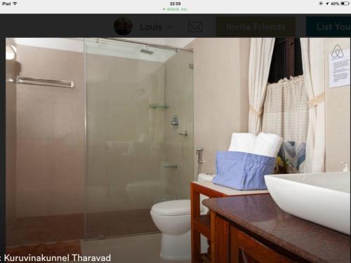 ein Bad mit einer Dusche, einem WC und einem Waschbecken in der Unterkunft Kuruvinakunnel Tharavadu in Kottayam