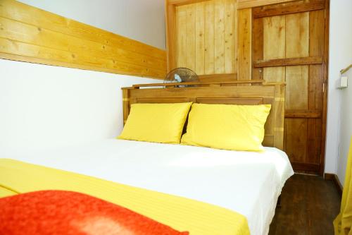 a bedroom with a bed with two yellow pillows at YOUTHENI VILLA in Weligama