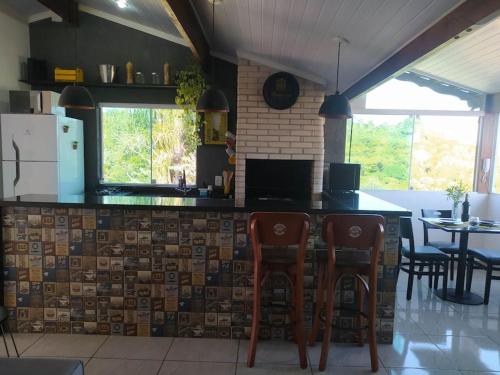 a kitchen with a counter with chairs and a table at Apartamento Por do Sol - Cobertura in São Roque