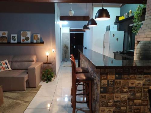 a kitchen and living room with a bar with a couch at Apartamento Por do Sol - Cobertura in São Roque