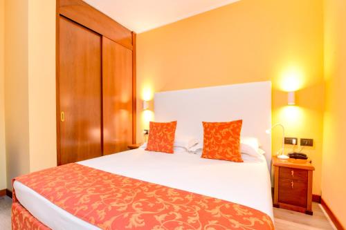 a bedroom with a large white bed with two pillows at Lido International in Desenzano del Garda