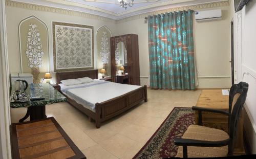 a bedroom with a bed and a table and a mirror at Grand Emir Residence in Bukhara