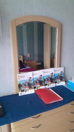 a desk with a mirror and a red folder on it at B & B Vandenbroucke Joseline in Ieper