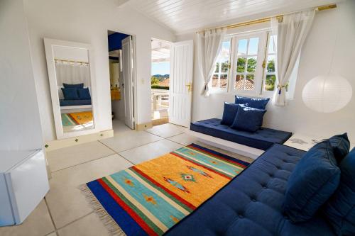a living room with a blue couch and a rug at Pousada Maré in Búzios