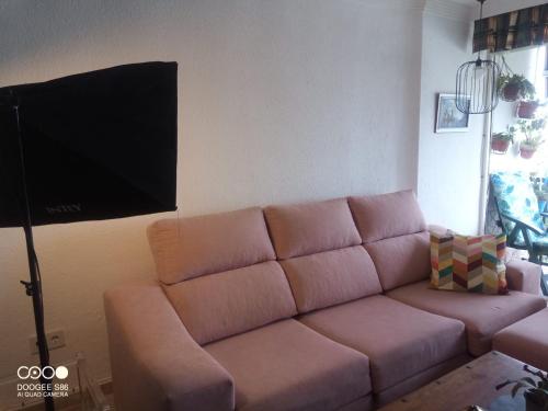 een woonkamer met een bank en een flatscreen-tv bij Coty's Beach in Benalmádena
