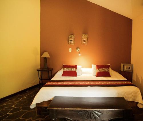 a bedroom with a large bed with red walls at Sarapiquis Rainforest Lodge in Sarapiquí