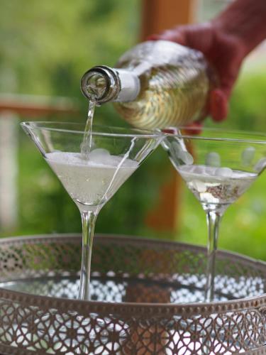 a person pouring a drink into a martini glass at Lensmannsgården in Namdalseid