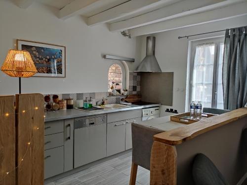 uma cozinha com armários brancos e uma mesa com um candeeiro em Atelier des sens 89 em Évry