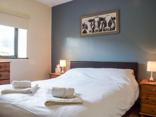 a bedroom with a white bed with two towels on it at Heyope Cottage in Llangunllo