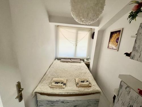 Cette petite chambre dispose d'un lit et d'une fenêtre. dans l'établissement Town Place Apartment, à Kardjali