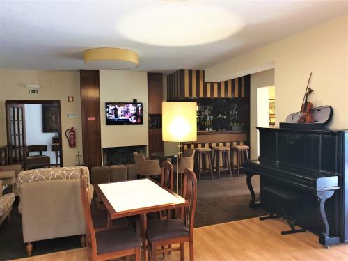 a living room with a piano and a bar at Hotel Verde Pinho Bed&Breakfast in São Pedro de Moel