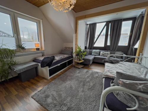 een woonkamer met een bank en ramen bij Ferienwohnung Kathis Eifelblick in Simmerath