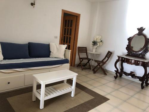 een woonkamer met een blauwe bank en een tafel bij Alloggio vista mare in Peschici