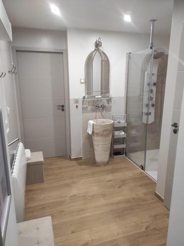La salle de bains est pourvue d'un lavabo et d'une douche. dans l'établissement Aux Charmes de la Vallée, à Béthisy-Saint-Pierre