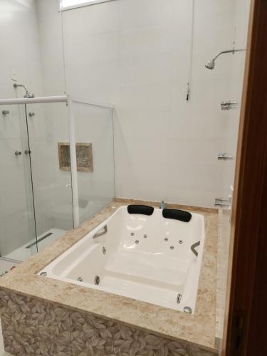 uma banheira na casa de banho com um chuveiro em Casaazulvaleparaiba em Jacareí