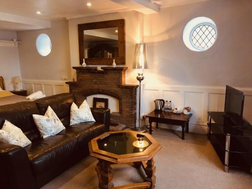 a living room with a couch and a fireplace at The Priory in Scorton