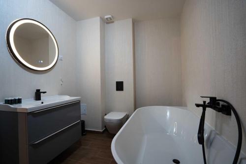 a bathroom with a tub and a sink and a mirror at Hotel Cristal in Cluj-Napoca