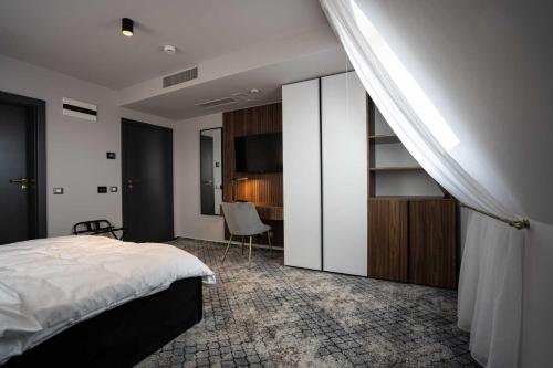 een slaapkamer met een bed, een bureau en een televisie bij Hotel Cristal in Cluj-Napoca