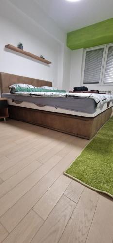 ein großes Bett in einem Zimmer mit grünem Teppich in der Unterkunft Luxury Green & Modern Apartment in Skopje