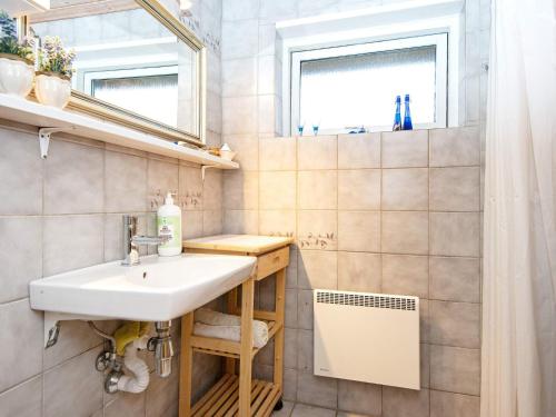 ein Bad mit einem Waschbecken und einem Spiegel in der Unterkunft Holiday home Hvide Sande CXV in Hvide Sande