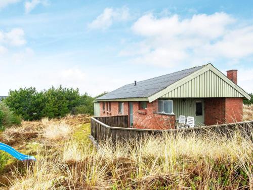 a small red brick house in the middle of a field at 7 person holiday home in Hvide Sande-By Traum in Hvide Sande