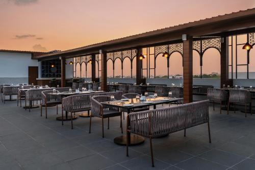 a restaurant with tables and chairs on a roof at Redolence Aravali Tree in Udaipur