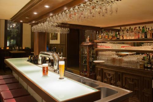 a bar with a sink and glasses of beer at Hotel Stadtpalais in Lemgo