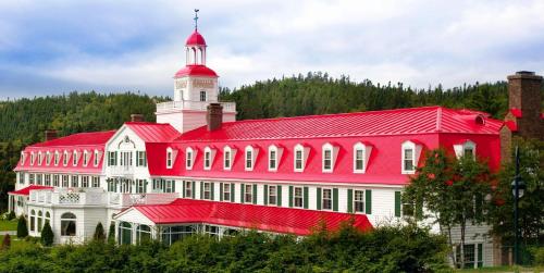 a large red and white building with a tower at Hotel Tadoussac in Tadoussac