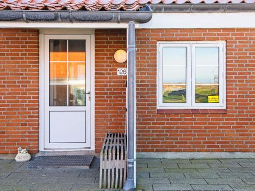 een stenen huis met een witte deur en een bank bij 6 person holiday home in Lemvig in Lemvig