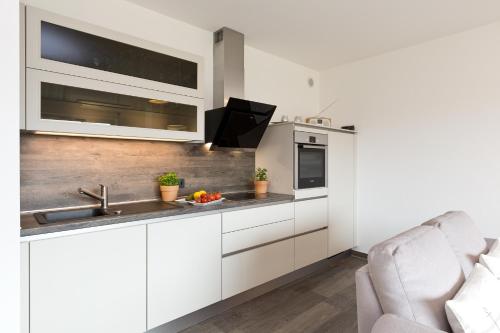 a kitchen with white cabinets and a sink at Kells Appartements in Klink