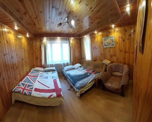 a bedroom with a bed and a chair in a cabin at Куренiвський Двiр in Kyiv