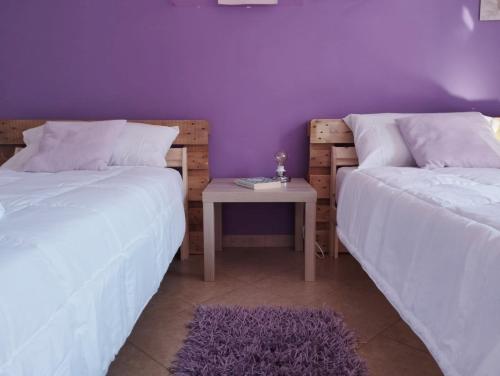 two beds in a room with a table between them at Ferula loft in Sortino