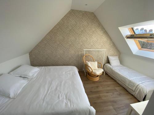 Dormitorio en el ático con cama y banco en Chambre chez Marjorie, en Brest