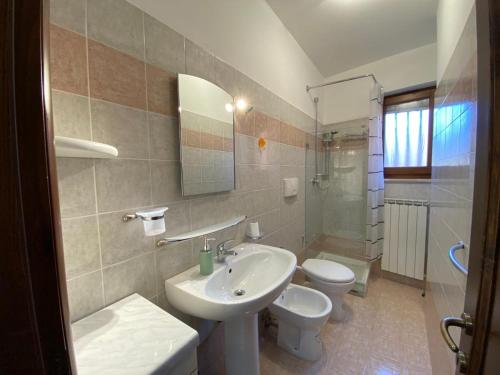 Un baño con lavabo, inodoro y espejo. en Casa Vacanze La Civita, en Castel di Sangro