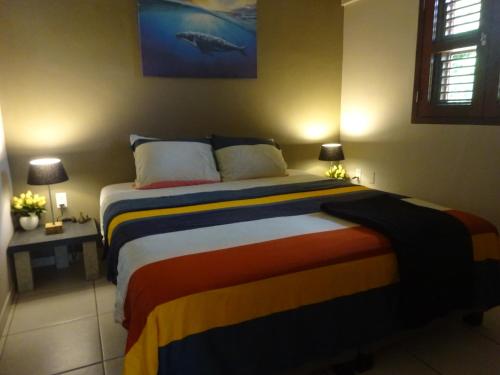 a bedroom with a bed with a colorful blanket at Yellow Palms in Kralendijk