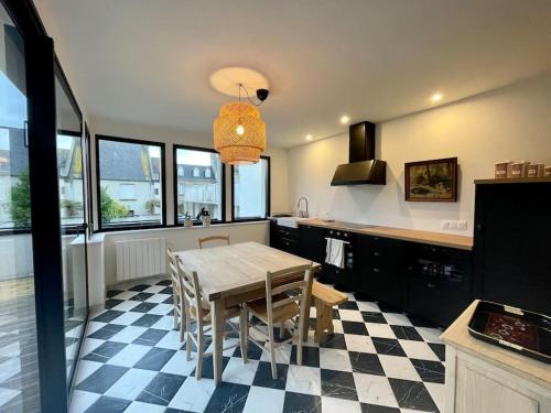 une cuisine avec une table et des chaises dans une pièce dans l'établissement Ty Dag - Terre de bas - plein centre parking privé, à Roscoff