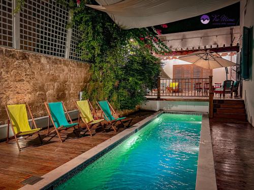 a swimming pool with chairs and a table at Via Mina Hotel in El Mîna