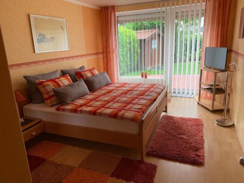 Schlafzimmer mit einem Bett mit einem Fenster und einem TV in der Unterkunft Im Kurpark Hage - Berum in Hage
