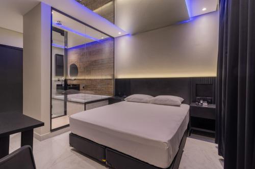 um quarto com uma cama grande e uma casa de banho em Drops Motel POA Zona Sul em Porto Alegre