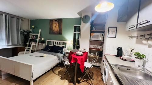 Kleines Zimmer mit einem Bett und einer Küche in der Unterkunft Studio avec wifi a Paris in Paris