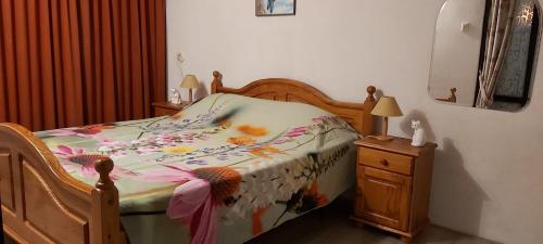 ein Schlafzimmer mit einem Bett mit einer Blumendecke darauf in der Unterkunft Klepperstee Esdoorn 3 in Ouddorp