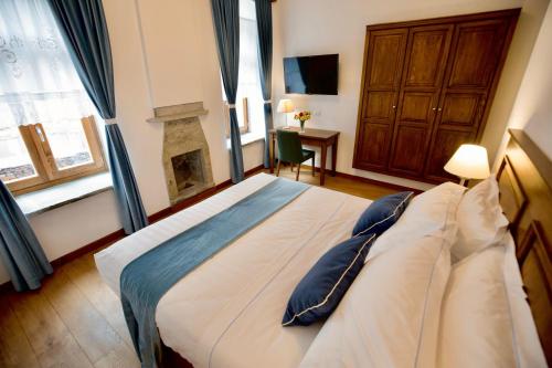 a bedroom with a large bed with a fireplace at VILLA PERMET in Përmet