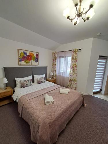 a bedroom with a large bed with two shoes on it at Alexander House in Deva
