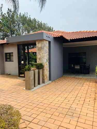 a house with a brick patio with a fireplace at Ultimate Sky-3 bedroom villa in Pretoria