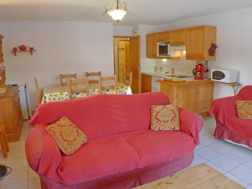 un salon avec un canapé rouge et une cuisine dans l'établissement Appartement 4 pièces au coeur de Samoëns - Résidence Les Grandes Alpes - FR-1-629-87, à Samoëns