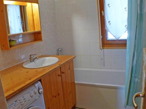 a bathroom with a sink and a washing machine at Appartement Samoëns, 4 pièces, 6 personnes - FR-1-629-87 in Samoëns